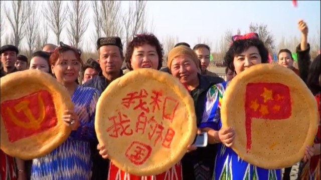Da sinistra a destra pani nan uiguri “decorati” con la falce e martello del PCC, lo slogan «io e il mio Paese» e la bandiera cinese nel corso delle celebrazioni di primavera svoltesi a Turpan, nello Xinjiang