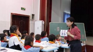 Un insegnante insegna cinese in una scuola elementare nello Xinjiang