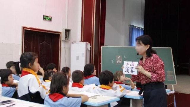 Un insegnante insegna cinese in una scuola elementare nello Xinjiang