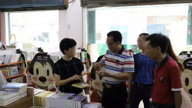 Funzionari governativi ispezionano le pubblicazioni in una libreria nella provincia del Guangdong