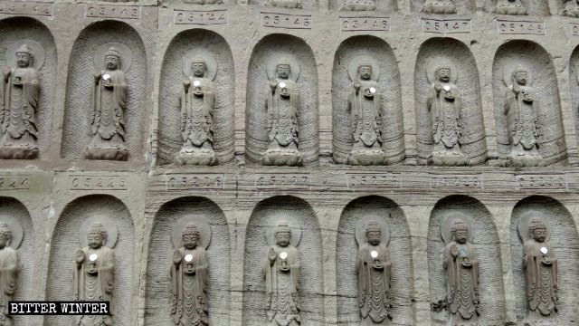 Primo piano delle statuette del Buddha intagliate nelle pareti