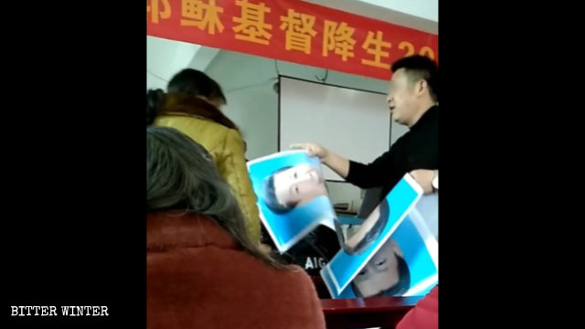 Un funzionario dell’amministrazione distribuisce ai fedeli i ritratti di Xi Jinping