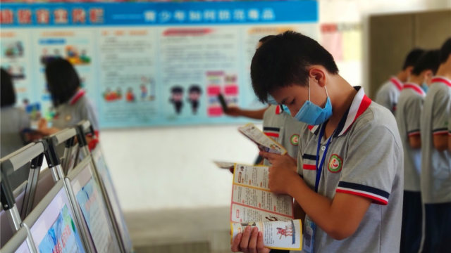 Uno studente legge del materiale propagandistico anti-xie jiao
