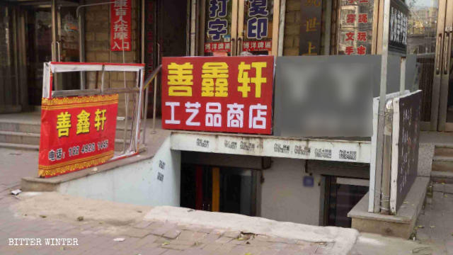 La targa del negozio di articoli buddisti «Shan Xin Xuan» è stata sostituita da un'insegna con scritto «Negozio di prodotti artigianali»