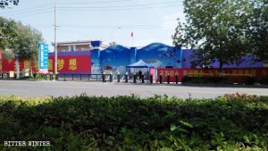 Il Parco industriale per la produzione tessile e l’abbigliamento della contea di Huocheng, nello Xinjiang, è stato trasformato in un campo di prigionia, ma il cartello con il nome del parco industriale è ancora affisso accanto al cancello