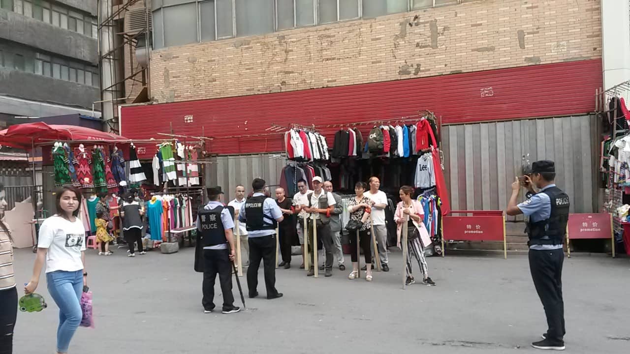 Agosto 2018: ambulanti di Urumqi fotografati dalla polizia della comunità dopo un’esercitazione "armata"