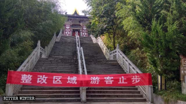 Questo striscione con scritto «Zona di rettifica, vietato l’accesso ai turisti" è appeso fuori dalla Porta dell'Unicià del Laojun Mountain Laozi Culture Garden