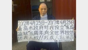 25 aprile 2017. Sun Jichang, a casa, mostra un cartello: “Restituitemi i diritti umani”