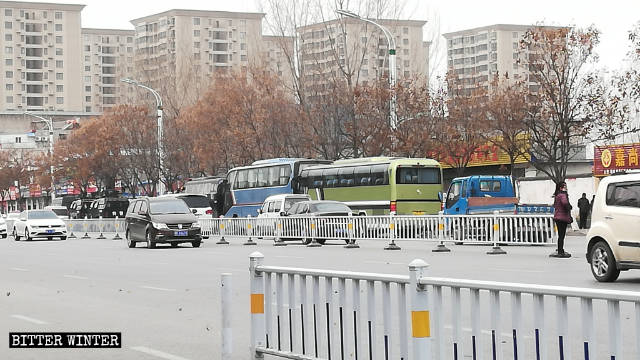 Auto e due grandi bus della polizia speciale fermi davanti all'hotel Haoyue