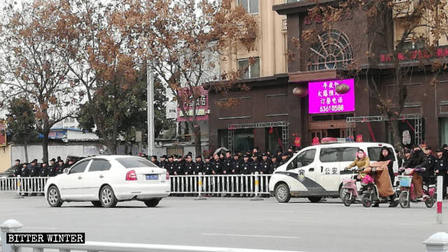 Gli agenti della polizia speciale disposti in tre file per bloccare l'ingresso davanti all'hotel Haoyue
