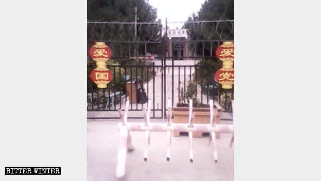 L’ingresso della moschea nel villaggio di Anjihai è chiuso a chiave e sopra di esso sono appese delle lanterne rosse con scritte le parole «Ama il Partito» e «Ama il Paese». Inoltre di fronte al cancello è stata posta una barriera per bloccare i veicoli