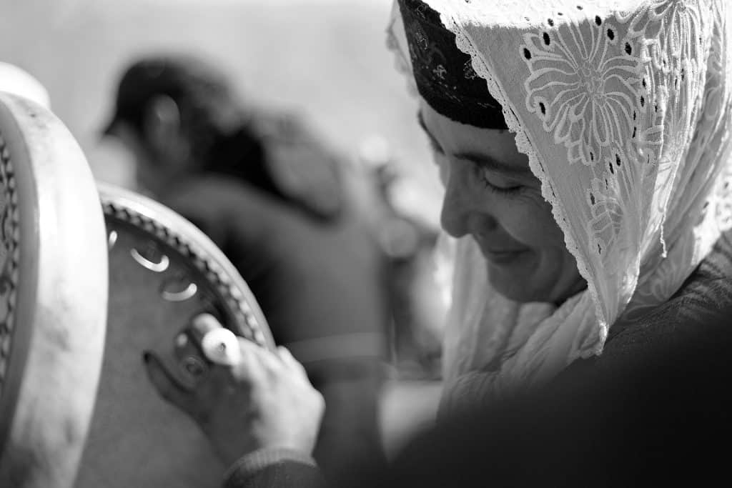 Una donna suona il daf (tradizionale tamburo persiano) durante un matrimonio.