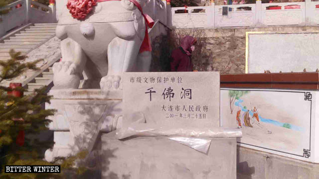 Una targa di marmo che indica che la Grotta dei mille Buddha è un sito storico e culturale sotto l'egida del comune