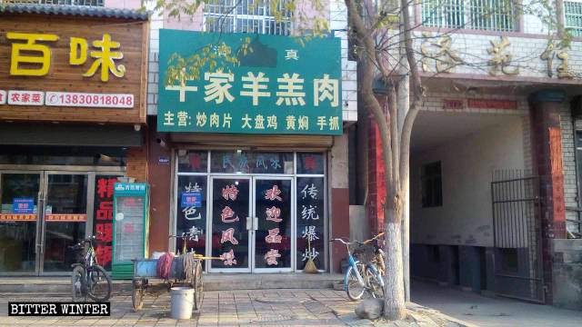 Un simbolo coperto sull'insegna di un ristorante specializzato in cibo alla griglia nel borgo di Luomen, sotto la giurisdizione della città di Tianshui, nel Gansu