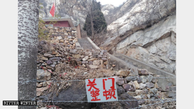 La strada che conduce al tempio di Taizi è stata bloccata con il filo spinato e su di esso è appeso un cartello con scritto «Chiuso per rettifica»