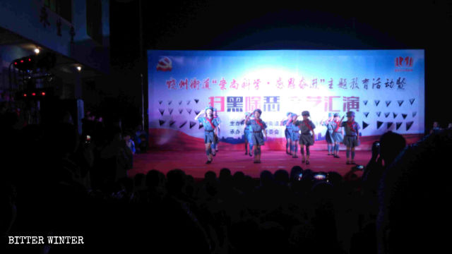 Bambini che interpretano canti e danze in lode del Partito Comunista
