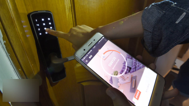 Un operaio sta testando la serratura intelligente con un'app dello smartphone