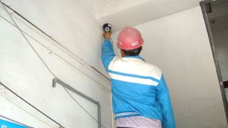 Un operaio installa una telecamera di sorveglianza