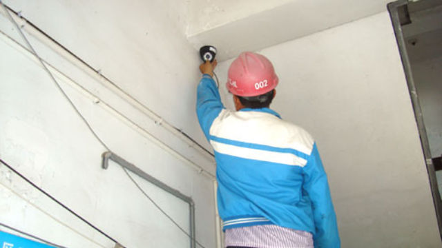 Un operaio installa una telecamera di sorveglianza