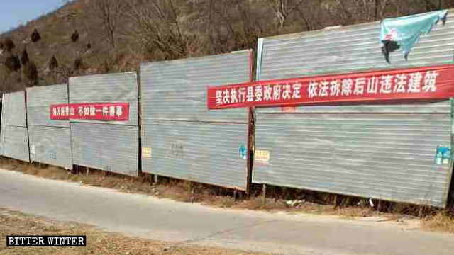 Slogan propagandistici sulla demolizione degli edifici illegali sono stati esposti lungo il sentiero che porta al tempio Nainai sul monte Hou