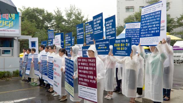 All'ingresso della sede della CDO a Onsu La protesta i fedeli mentre protestano contro il PCC che ne usa i familiari per inscenare manifestazioni false