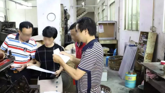 Funzionari controllano una tipografia nella provincia del Guangdong