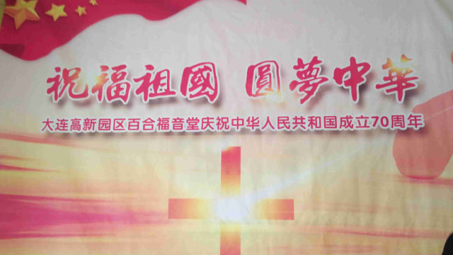 Un manifesto propagandistico che reclamizza Ode alla patria e realizzazione del sogno cinese all'ingresso di una chiesa