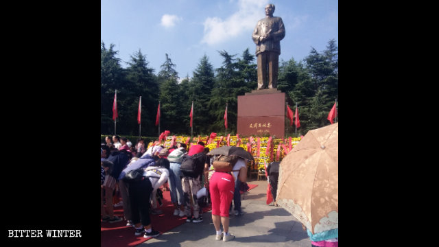 Turisti in preghiera di fronte alla Piazza della statua bronzea di Mao nella città di Shaoshan, nella provincia centrale dell’Hunan