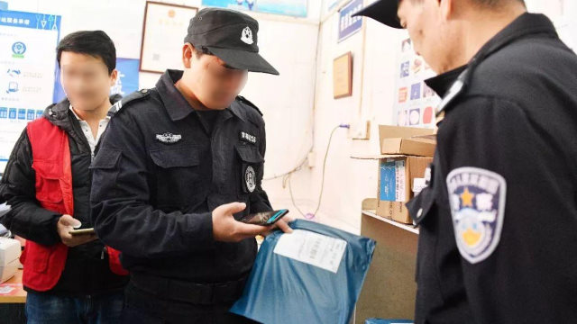 Agenti di polizia esaminano i pacchi utilizzando un'applicazione mobile