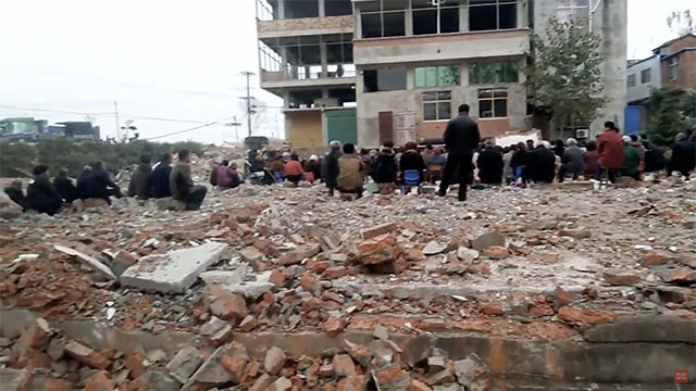 Cristiani di una contea del Fuyang sono riuniti in un campo di rovine
