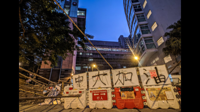 Blocchi stradali per resistere agli attacchi della polizia all'ingresso dell'Università di Hong Kong
