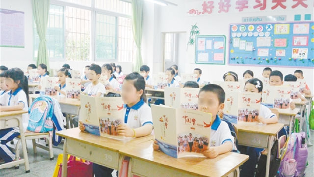 Scolari della scuola elementare della città di Jiangmen, nel Guangdong, leggono Il sogno della Cina, il mio sogno, libro di testo sul Pensiero del presidente Xi Jinping sul socialismo con caratteristiche cinesi per una nuova era