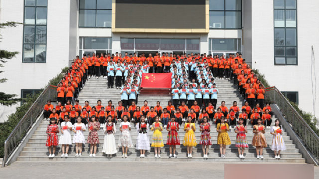 Studenti originari dello Xinjiang che frequentano Scuola professionale infermieristica di Jinan, capitale della provincia orientale dello Shandong, prendono parte alla cerimonia dell’alzabandiera in occasione della Festa nazionale