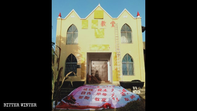 Fogli di compensato nascondono i simboli religiosi sulla parete esterna della chiesa delle Tre Autonomie nel borgo di Zhengcun