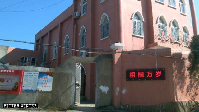 Uno schermo elettronico che mostra la frase «Lunga vita alla patria» è stato installato sul muro esterno della chiesa di Qiqiutian